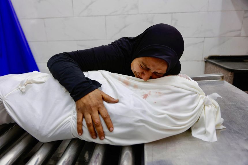 Palestinian Asma al-Zawarah, 37, hugs the body of her son Mohammed at the morgue of Al Shifa Hospital in Gaza City, on January 24, 2026.