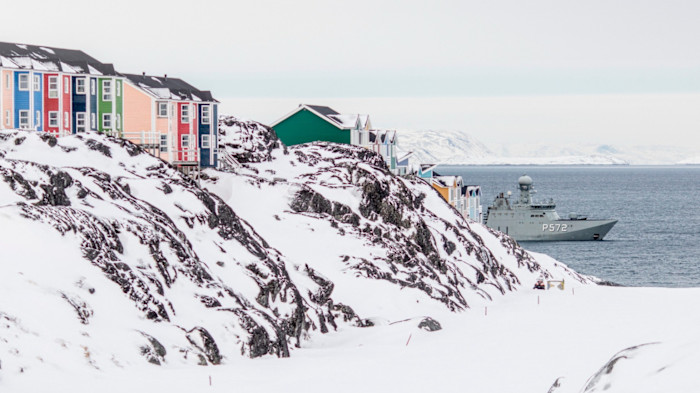 A Danish frigate marked P572 is seen in icy waters near colourful houses and snow-covered rocks in Nuuk, Greenland.
