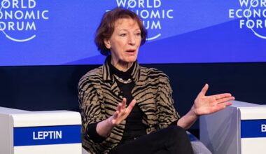 Maria Leptin speaks with hands extended while seated on stage during a World Economic Forum session.