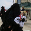 Women carry children near the al-Hol camp in Syria's Kurdish-majority region of Rojava. The camp is filled with more than 72,000 people — most of them women and children who came out of the last ISIS-held territory.
