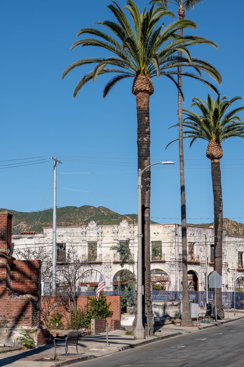 Damaged buildings are seen in downtown Pacific Palisades a year after the Palisades Fire.