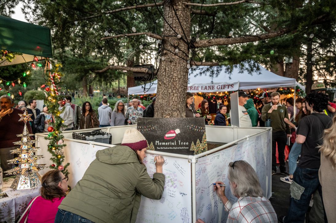 Residents in Altadena sign a memorial with notes of hope and remembrance ahead of the lighting of Christmas Tree Lane.