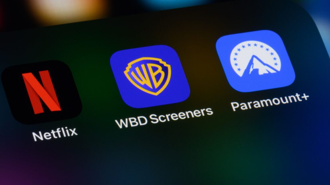 A smartphone screen displays app icons for Netflix, Warner Brothers Discovery, and Paramount Plus.