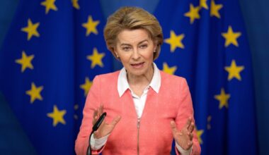 European Commission President Ursula von der Leyen speaking in front of an E.U. flag