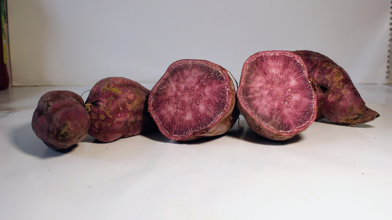 Sliced and whole purple potatoes