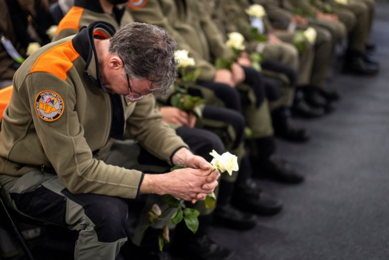 A member of the civil protection service holds a white rose at the end of the official commemorative ceremony and the national day of mourning following the deadly fire at the "Le Constellation" bar in Crans-Montana at the Martigny Expo (CERM) Exhibition and Convention Centre, in Martigny, Switzerland, January 9, 2026. MICHAEL BUHOLZER/Pool via REUTERS
