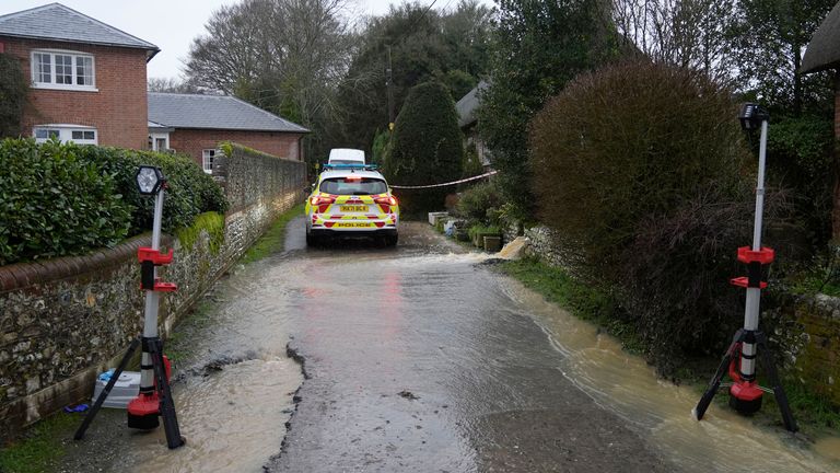 Police securing the scene around the country lane, which was flooded in Friday's heavy rain. Pic: PA