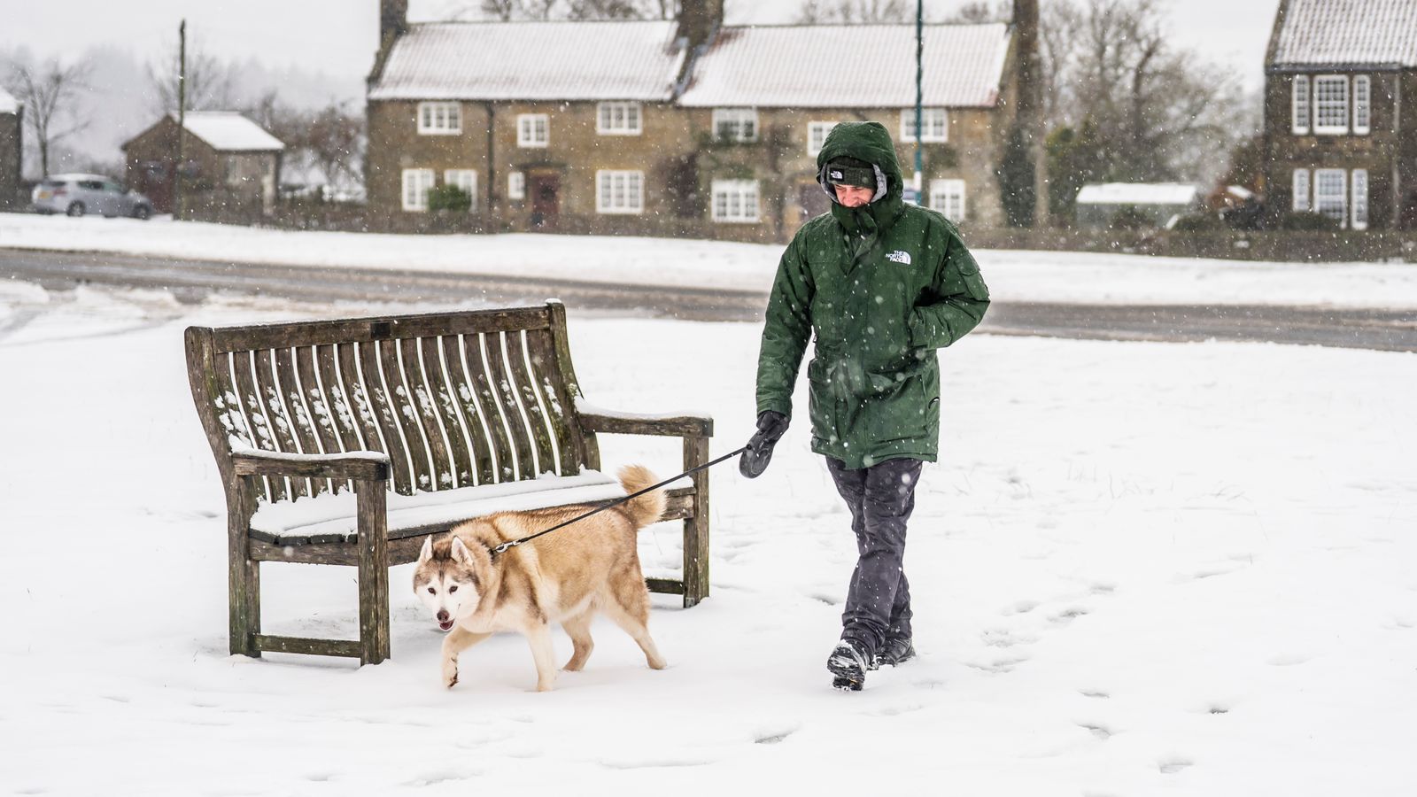 A man walks his dog in Goathland in the North York Moors National Park during snowfall earlier this month. Pic: PA