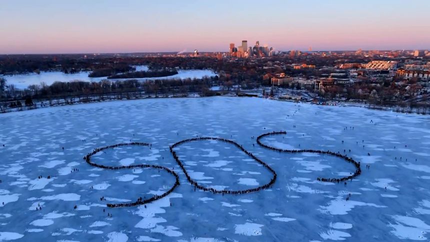 People gather to form a human distress signal on Bde Maka Ska in Minneapolis on Friday.