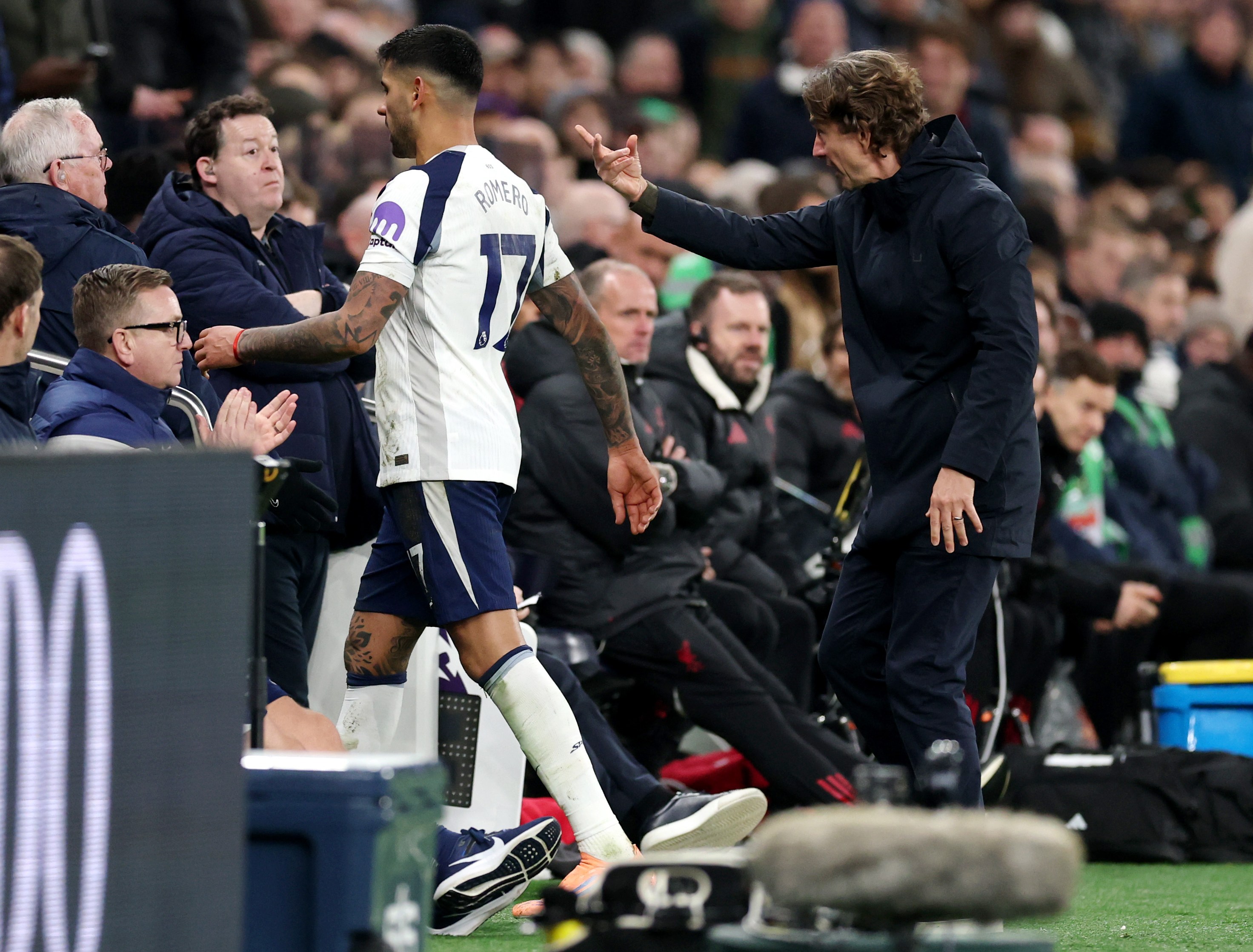 Tottenham Hotspur manager Thomas Frank forces Cristian Romero down the tunnel after Romero received a second yellow card.