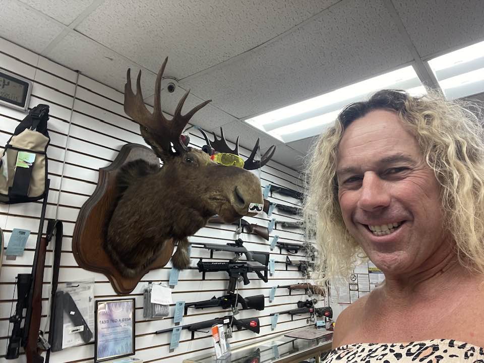 Roberta Esposito posing with a moose head in a gun store.