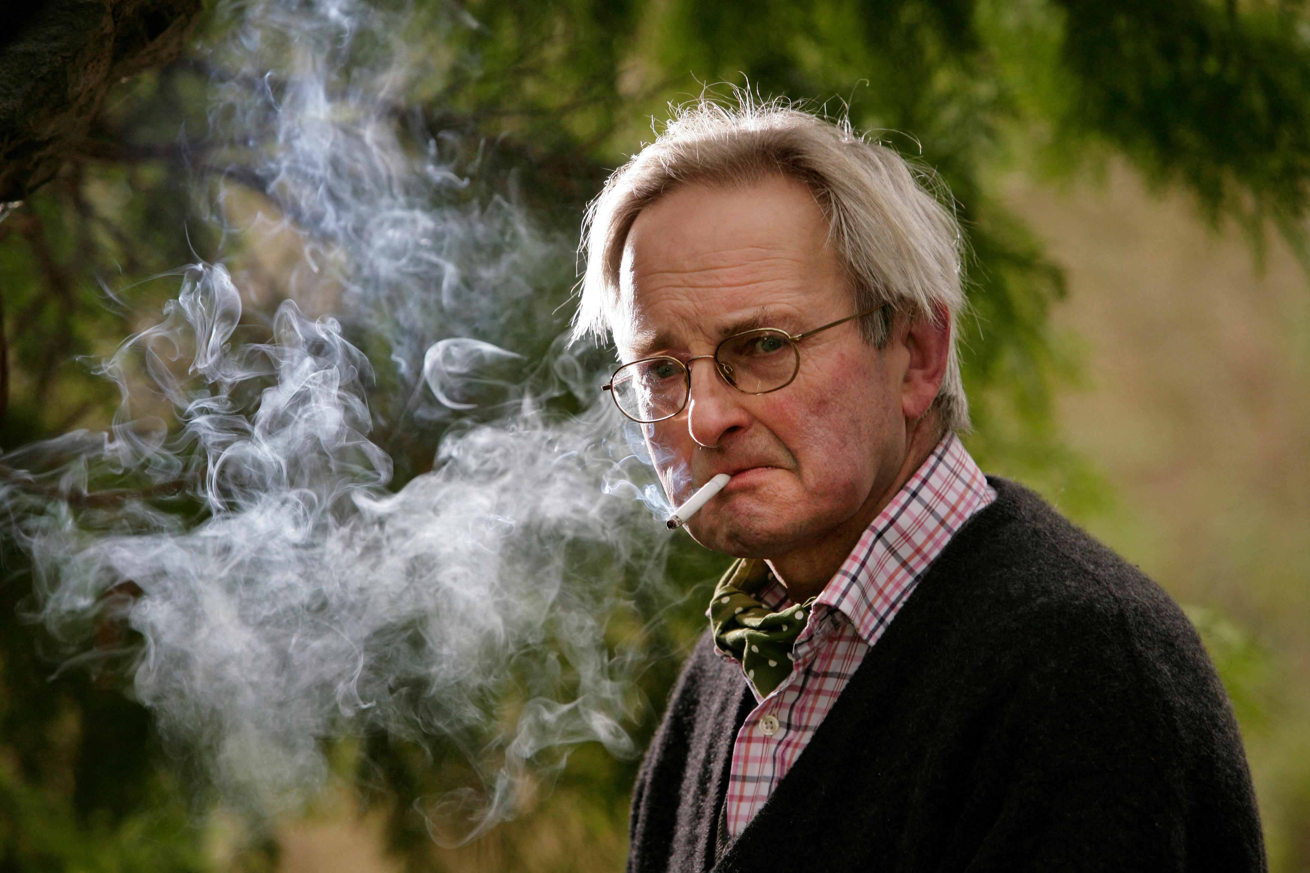 Allan Massie, Scottish journalist, columnist, sports writer, and novelist, smoking a cigarette.