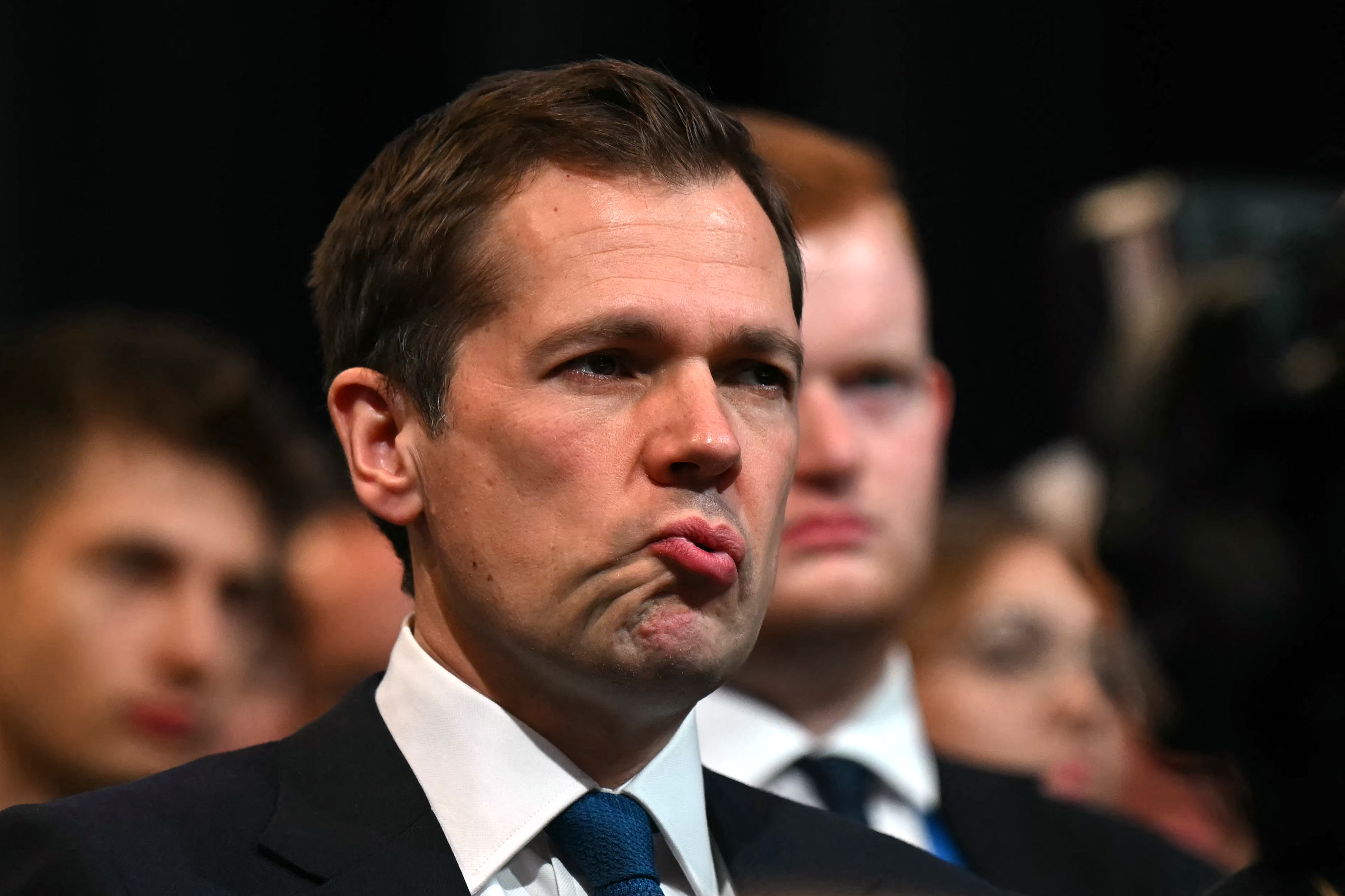 Robert Jenrick, Shadow Justice Secretary, listens intently during Kemi Badenoch's speech.