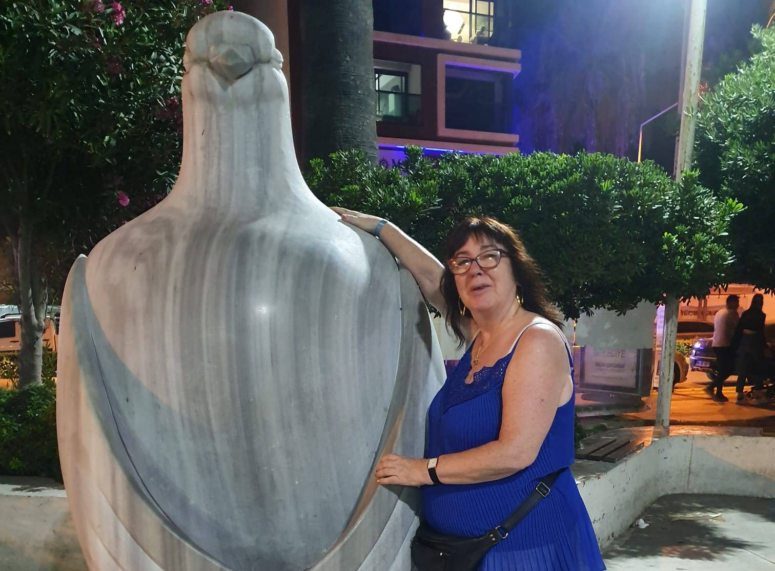 Lorna McSorley posing next to a large marble sculpture of a bird.
