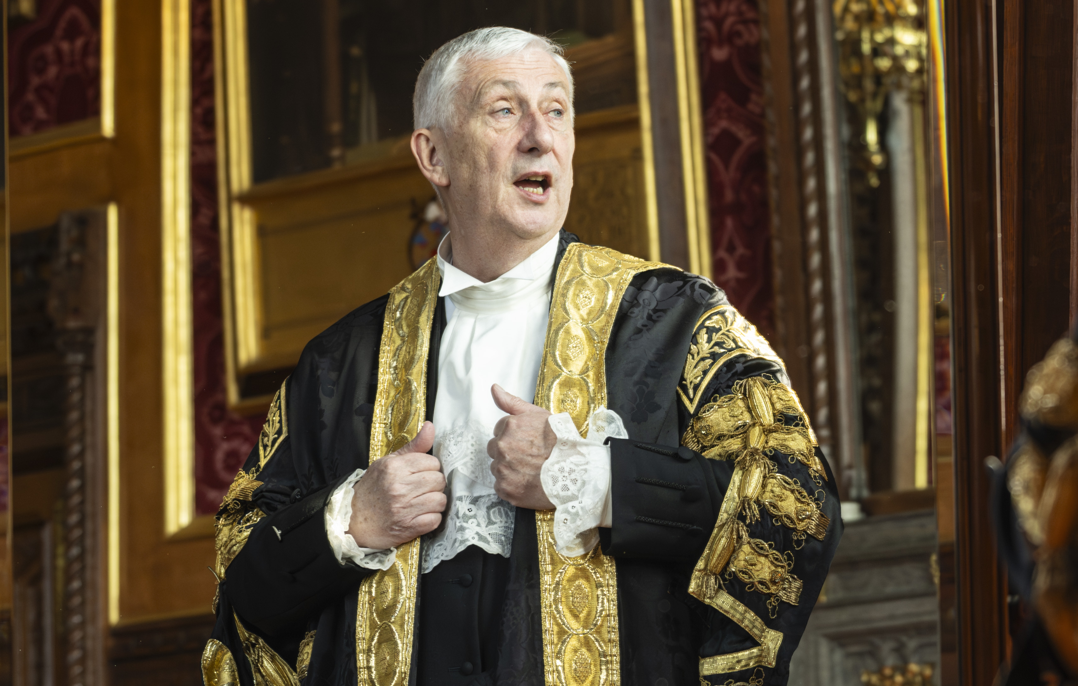 Speaker Sir Lindsay Hoyle in a formal black and gold robe and white jabot, with his hands making thumbs-up gestures.