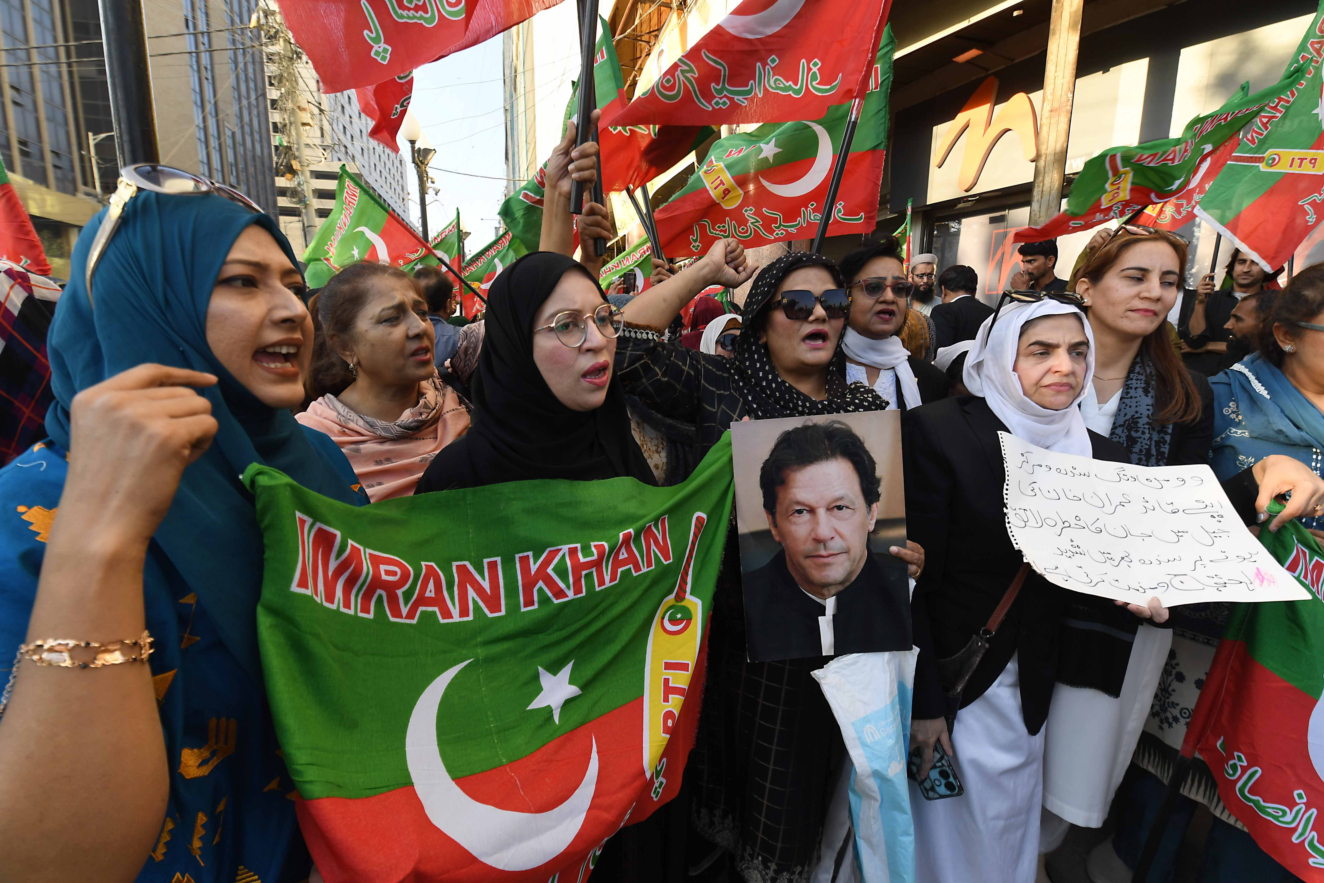 Supporters of the Pakistan Tehreek-e-Insaf (PTI) party protest, displaying portraits of Imran Khan and banners with his name.