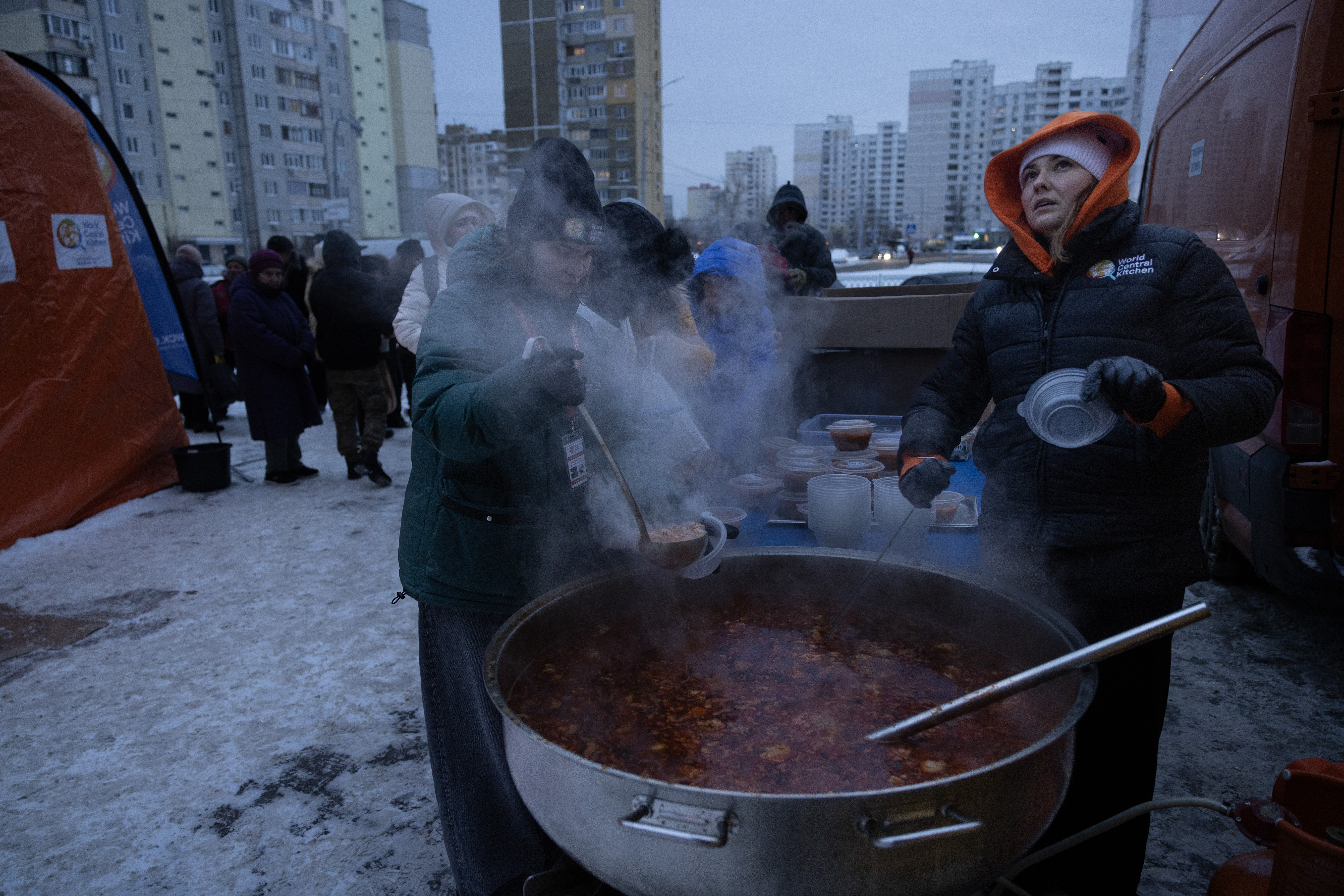 World Central Kitchen workers serve hot soup to Kyiv residents from a large pot.