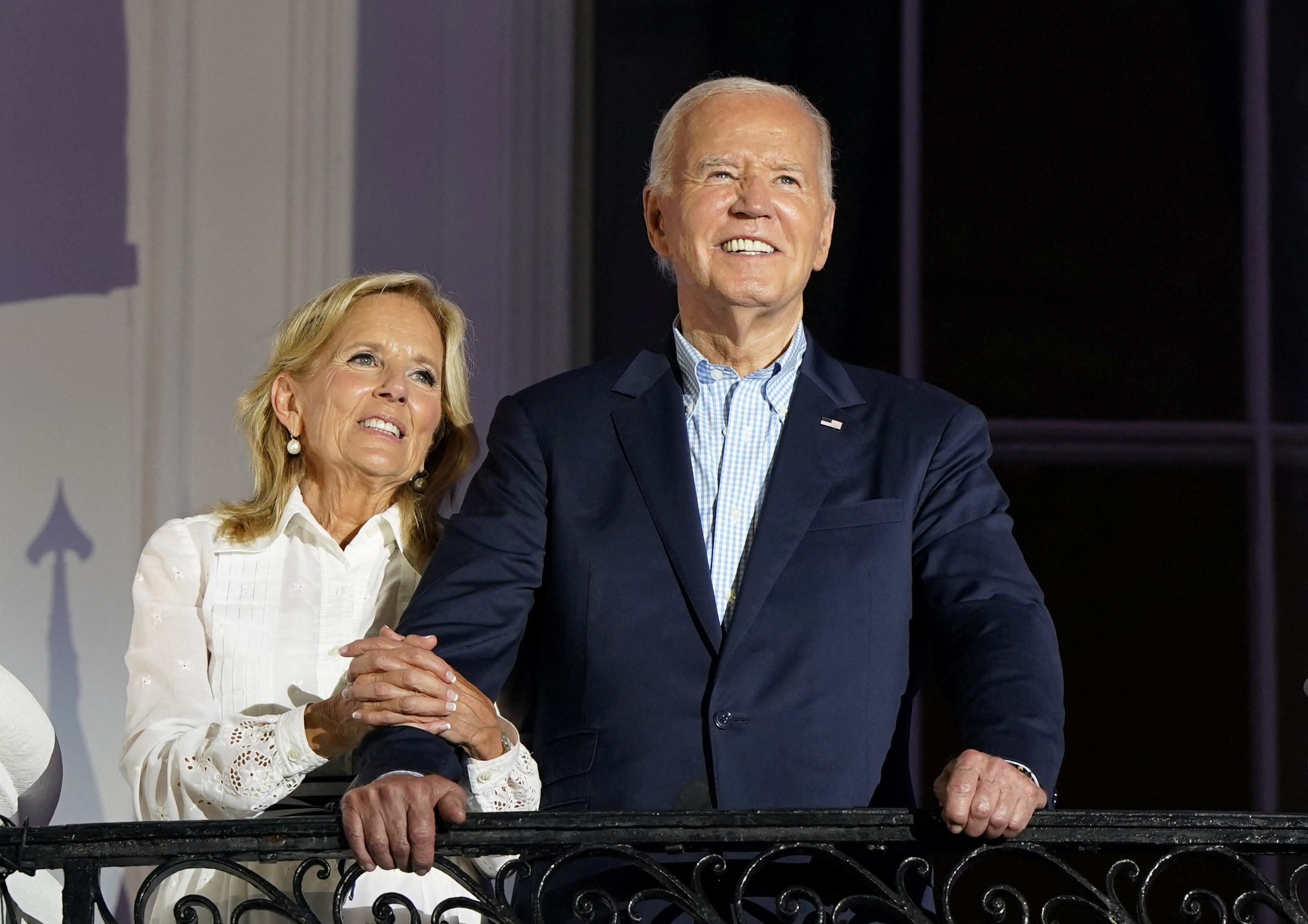 President Joe Biden and First Lady Jill Biden stand on a balcony at the White House.