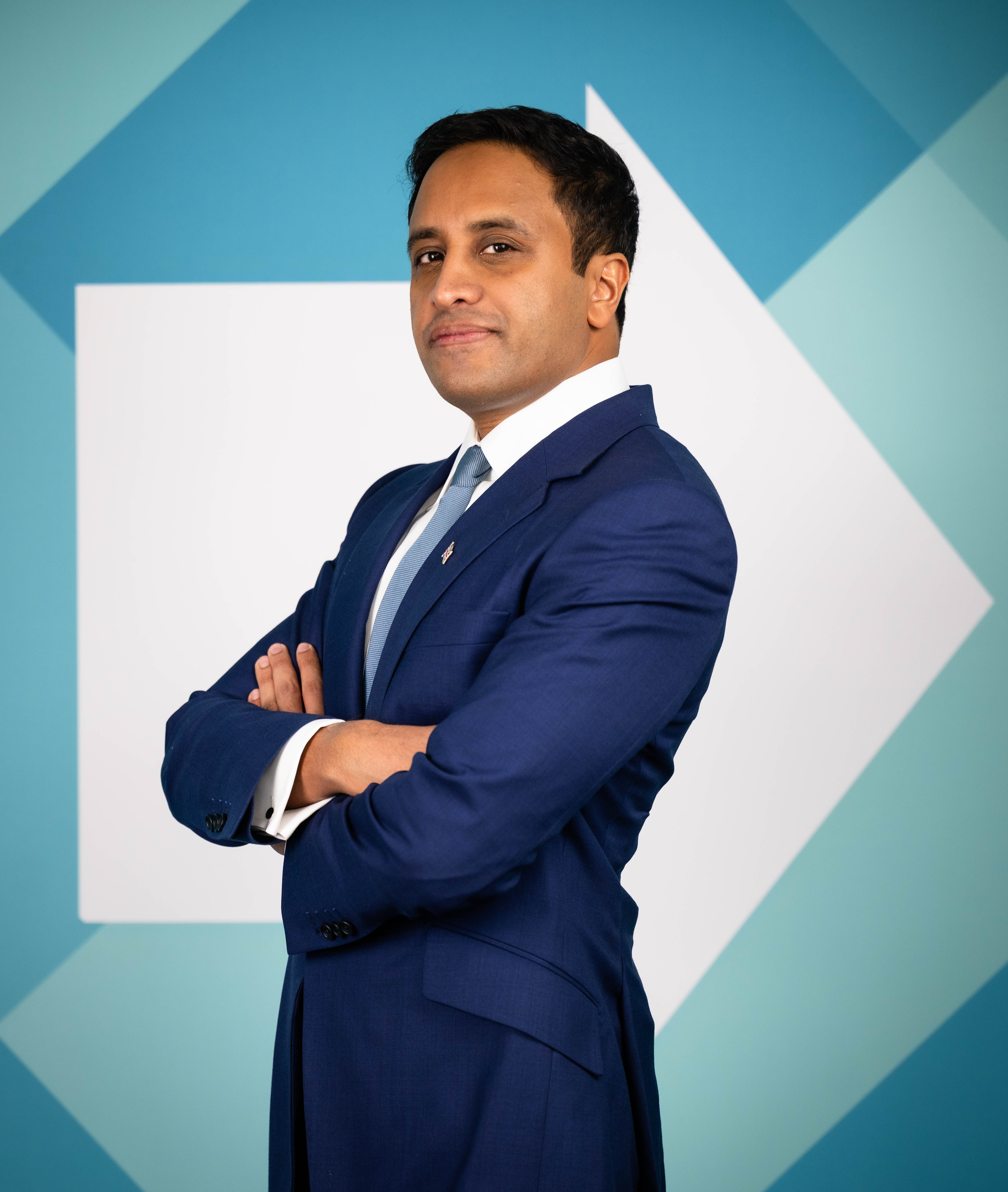 Zia Yusuf, Reform UK's Spokesperson for Home Affairs, wearing a blue suit and tie, with his arms crossed.