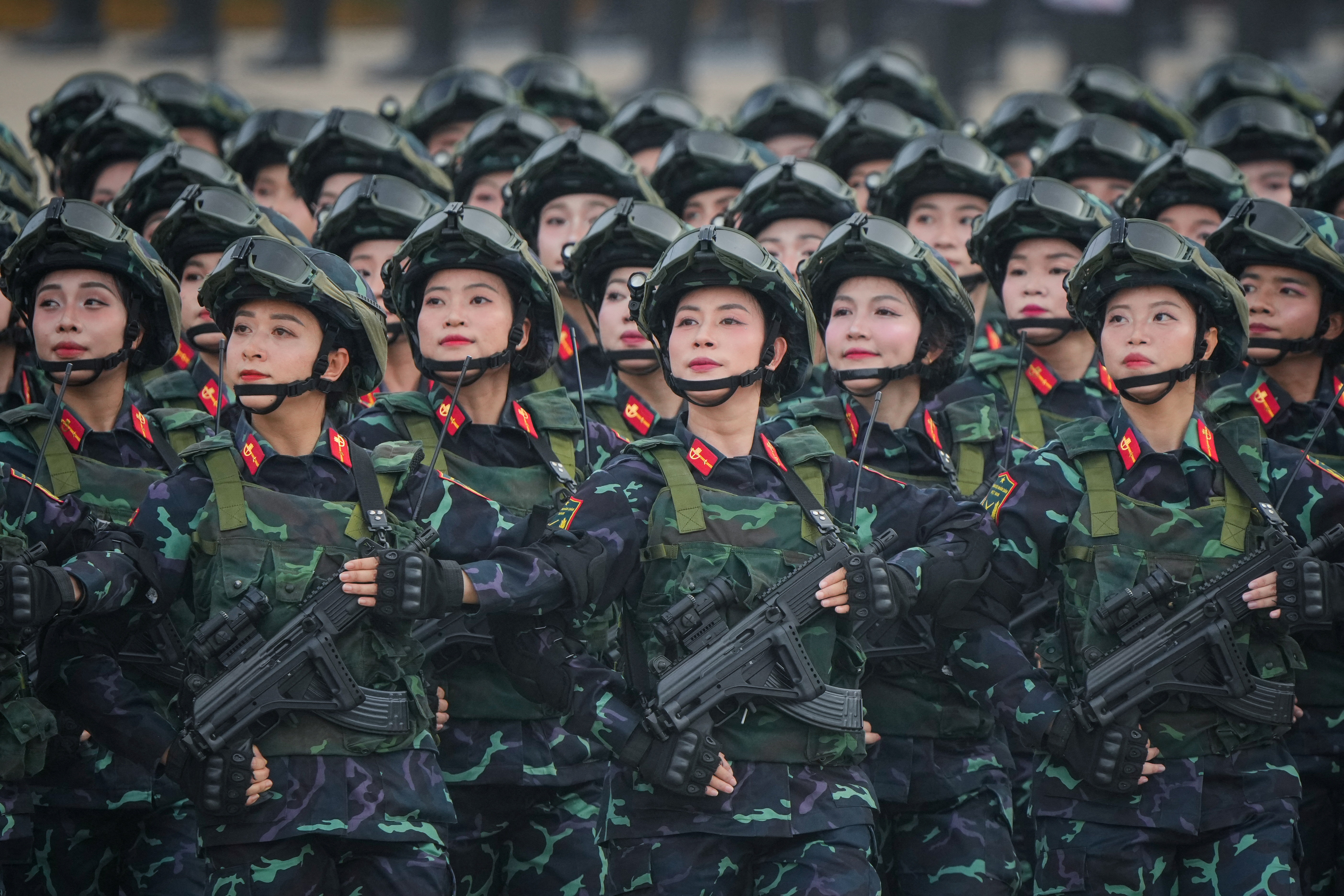 Vietnamese troops in camouflage uniforms and helmets participate in a parade.