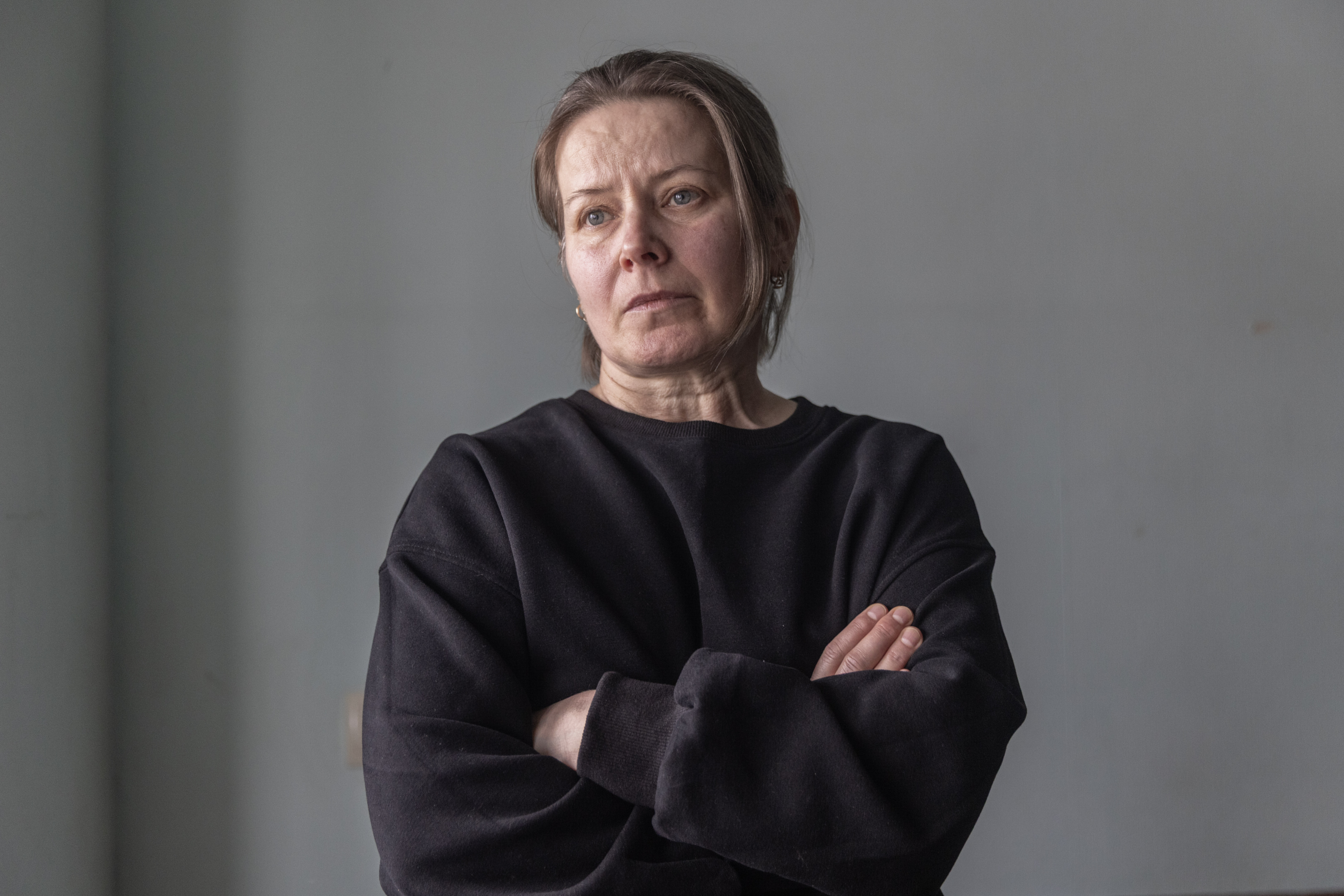 Oksanna Zyma, Valentina's sister, stands in Kyiv with her arms crossed, looking distressed.