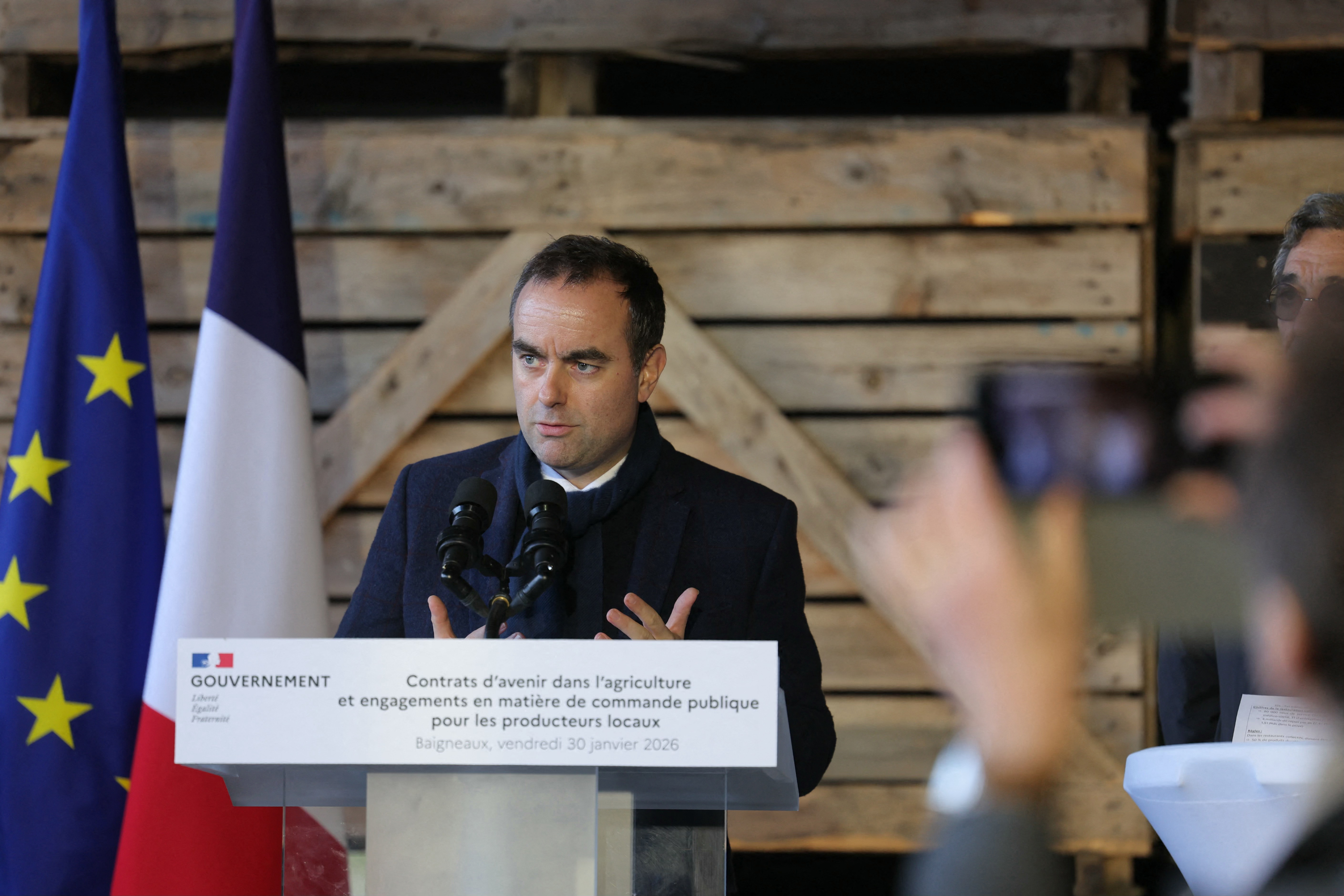 France's Prime Minister Sebastien Lecornu speaks at a press conference with EU and French flags behind him.