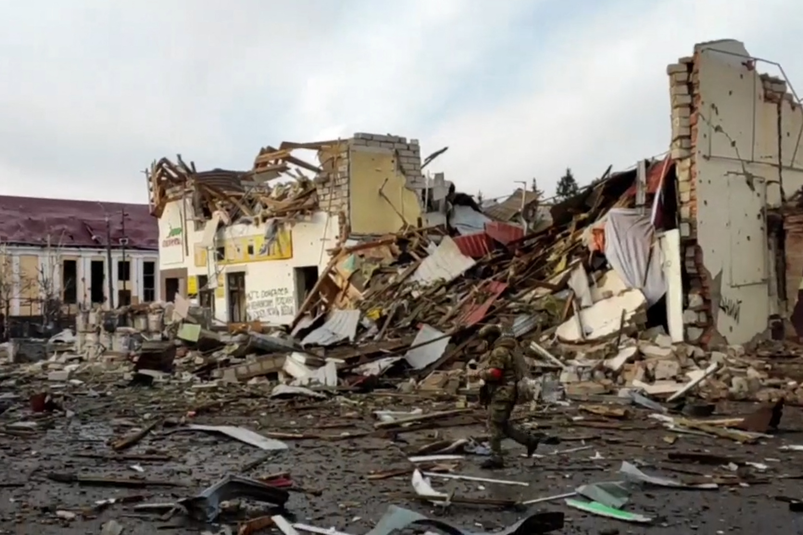 A Russian soldier walks past destroyed buildings in Sudzha, Kursk region.