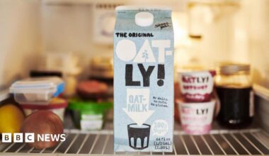 A carton of Oatly in a fridge.