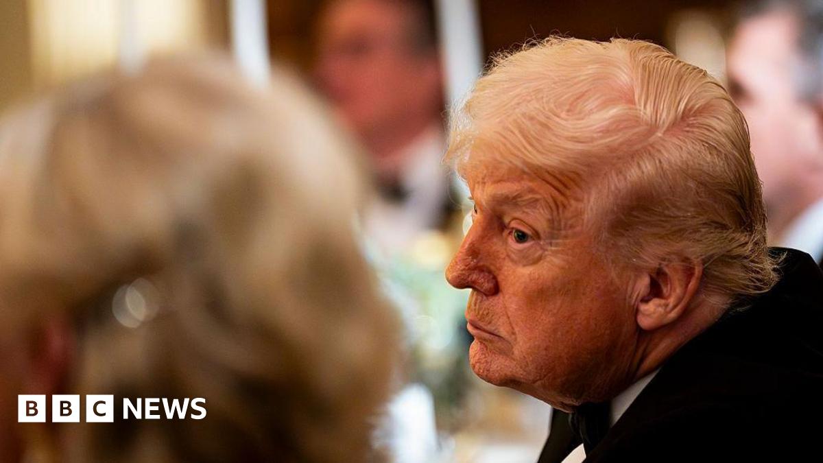US President Donald Trump leans over to look at a fellow attendee of a black-tie event