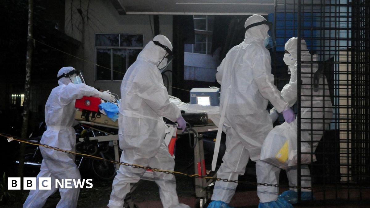 A picture of 3 people wearing white suits. They have masks on.