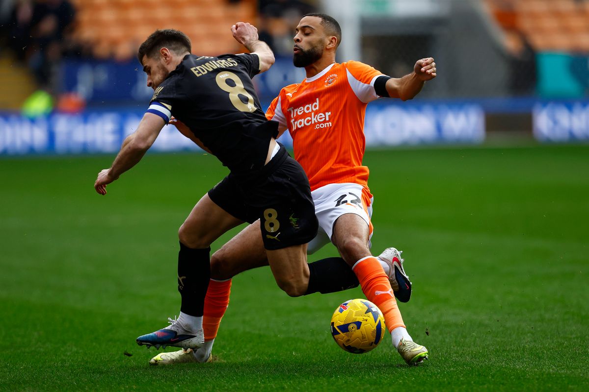 Argyle captain Joe Edwards battles for the ball with Blackpool's CJ Hamilton during the League One game at Bloomfield Road on 14 February, 2026 - (Photo by Steve Taylor/PPAUK)