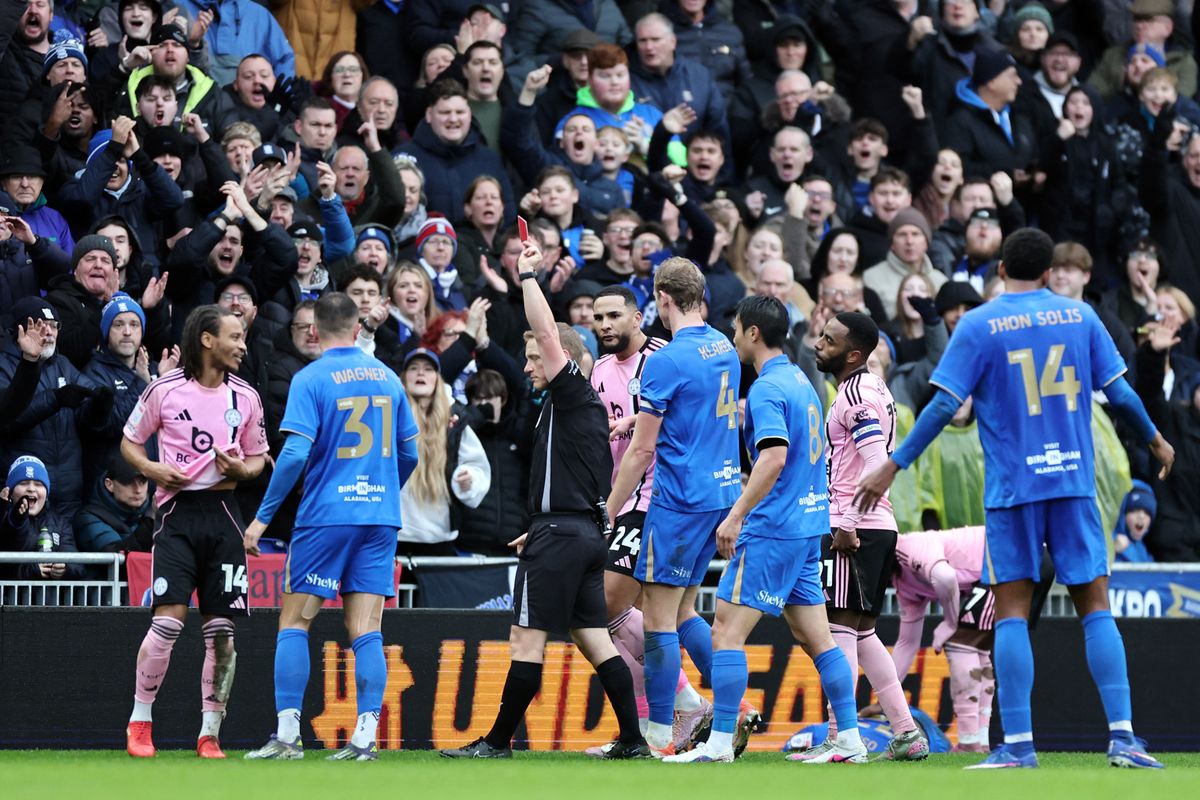 Referee John Busby shows a red card to Bobby De Cordova-Reid of Leicester City