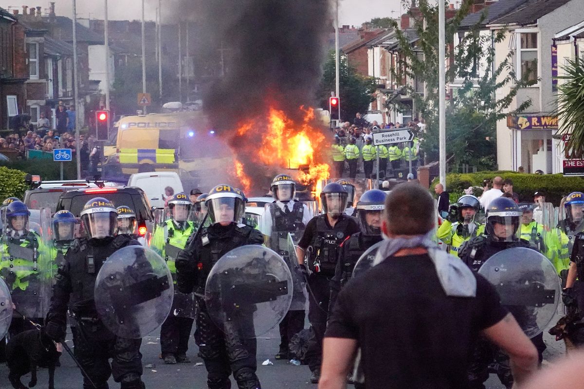 Riot police hold back protesters after disorder broke out in Southport in 2024