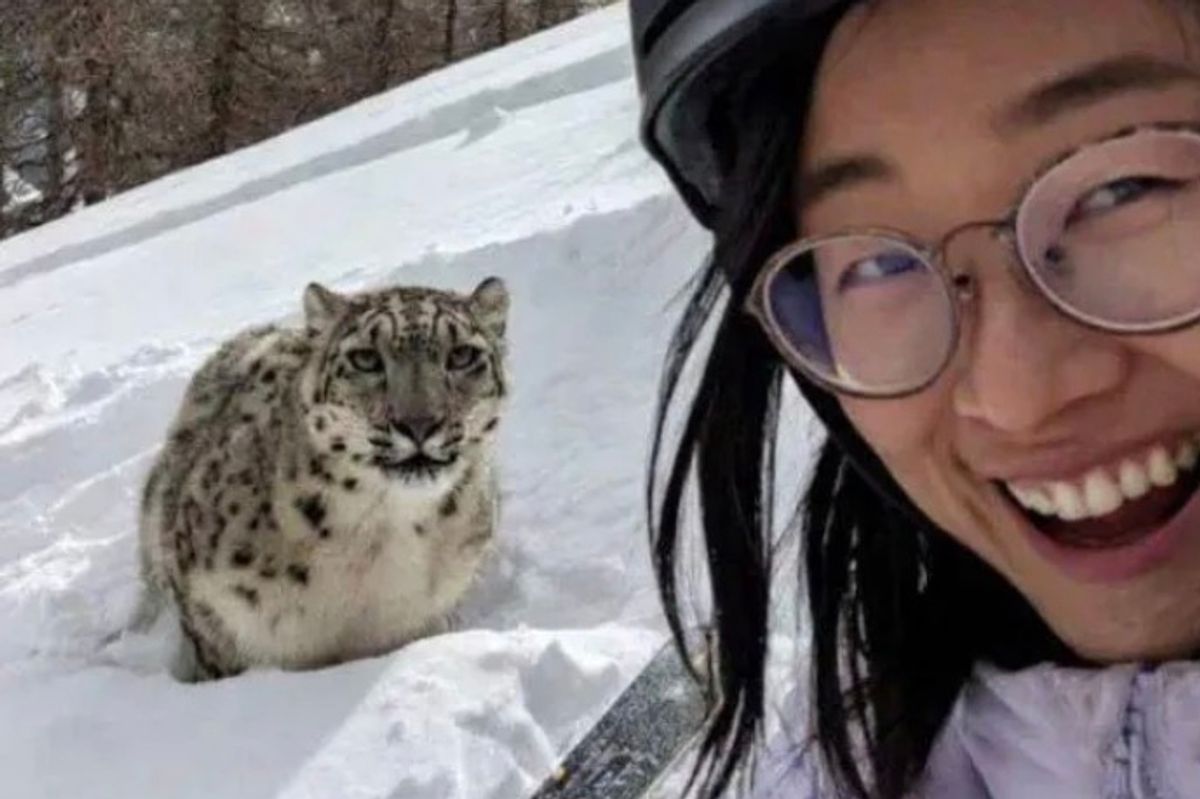Woman takes a selfie with a snow leopard