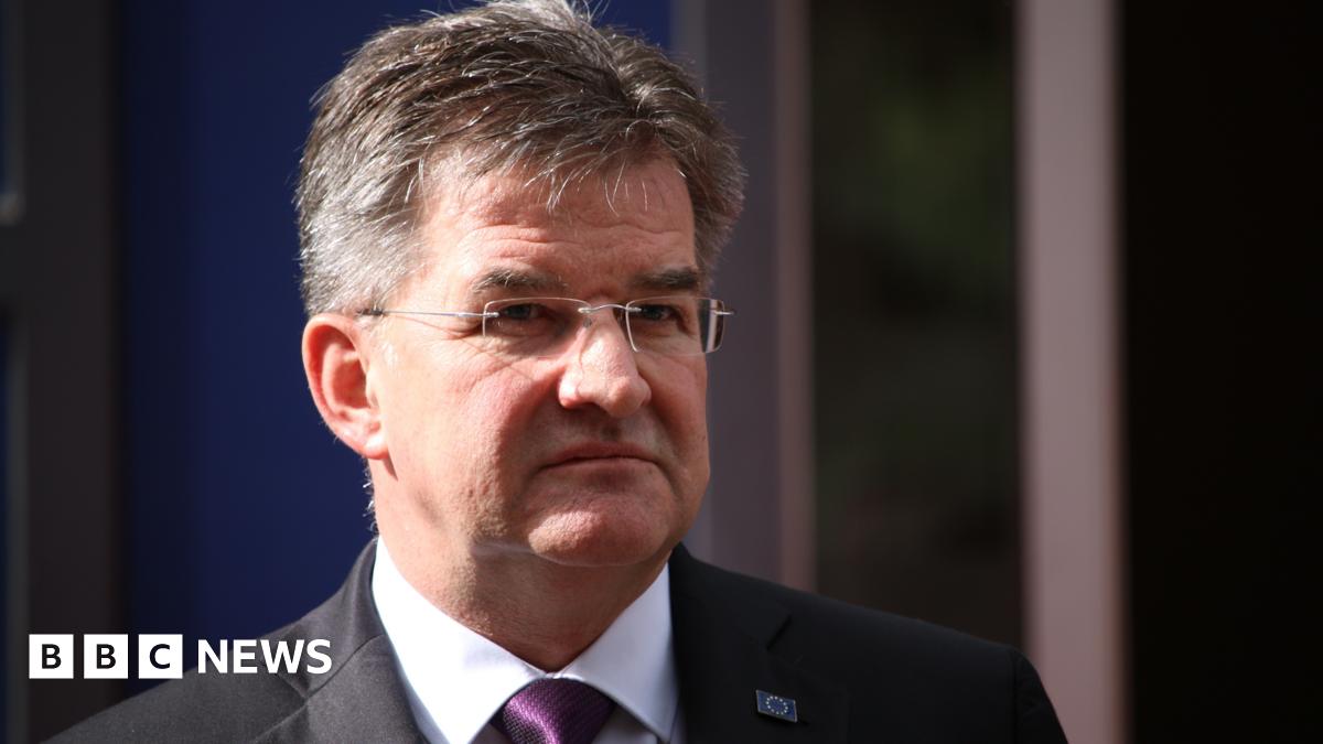 Miroslav Lajčák wears a suit, white shirt and purple tie.