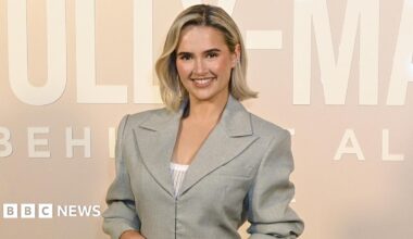 Molly-Mae Hague wearing a grey jacket on a pale pink background