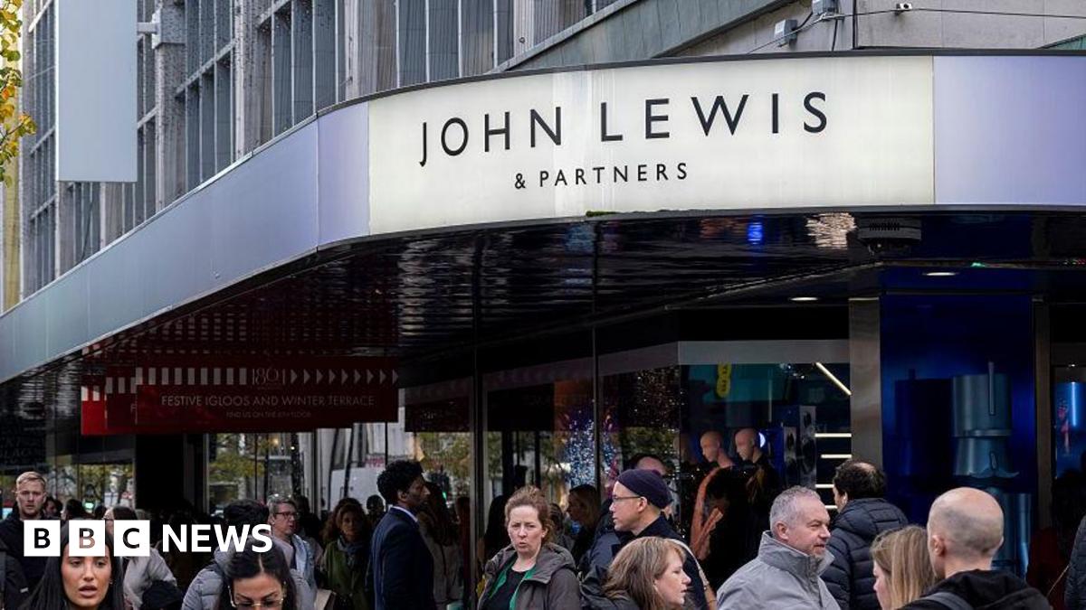 The sign of the Oxford Street John Lewis shop in London with a bustling street below it
