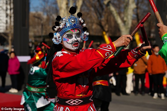 Dancers performing during a procession Lunar New Year celebrations in Beijing, China, today