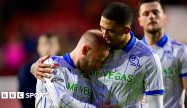 Former Sheffield Wednesday captain Barry Bannan, wearing the club's away shirt of white with royal blue collar and vertical pinstripes, is comforted by team-mate Liam Palmer after a game