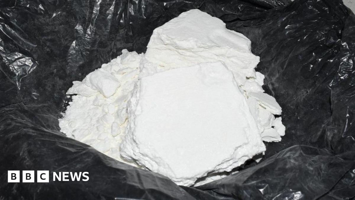 A large pile of soft white powder lies in the middle of a black plastic bag