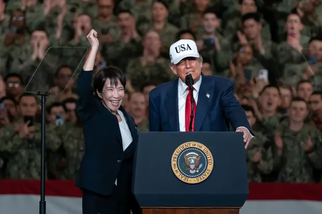 Takaichi and Trump smile at a podium