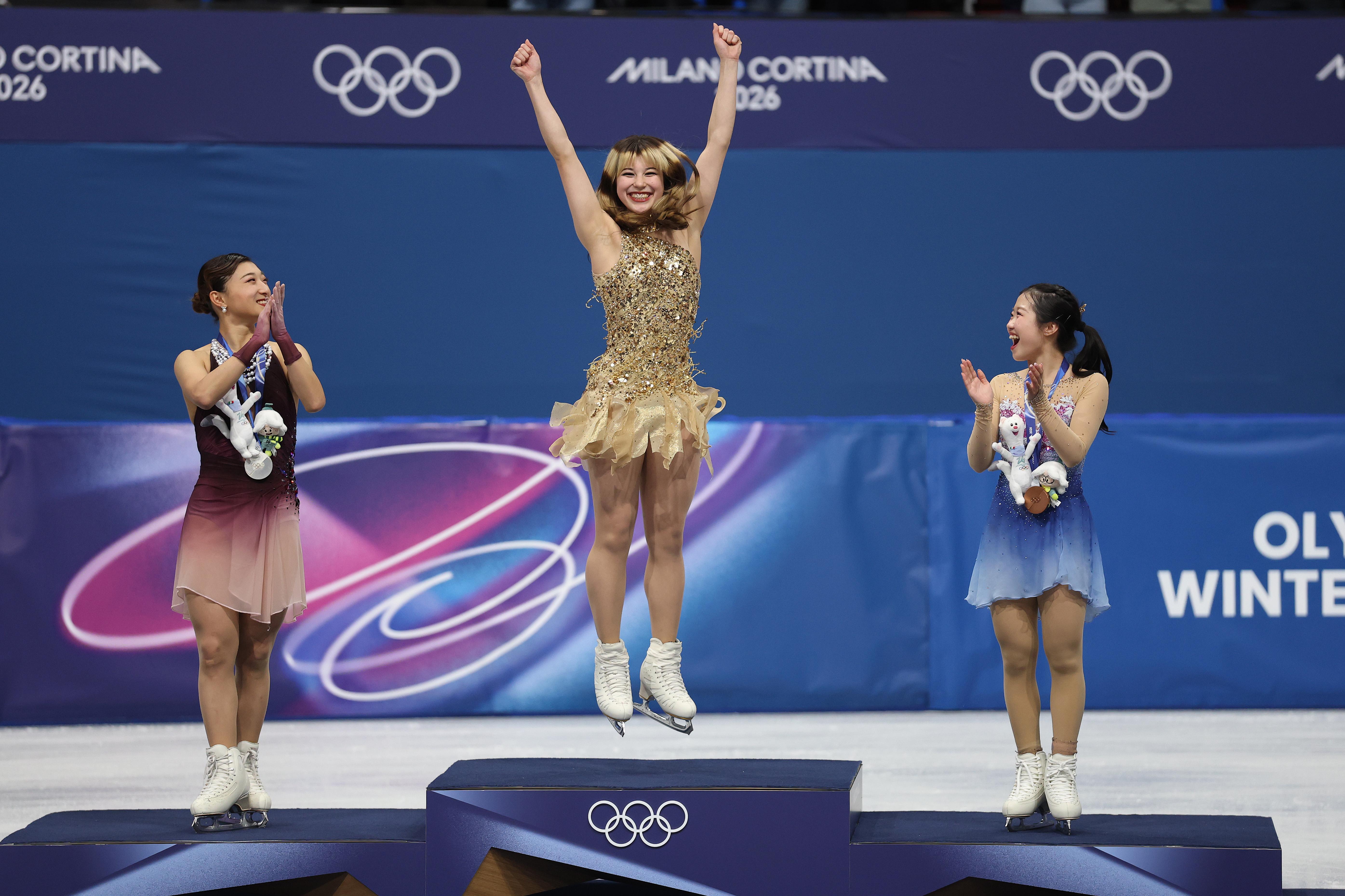 MILAN, ITALY - FEBRUARY 19: Gold medalist Alysa Liu of Team United States, silver medalist Kaori Sakamoto of Team Japan and bronze medalist Ami Nakai of Team Japan celebrate on the podium during the medal ceremony for the Women's Single Skating on day thirteen of the Milano Cortina 2026 Winter Olympic games at Milano Ice Skating Arena on February 19, 2026 in Milan, Italy. (Photo by Jamie Squire/Getty Images)