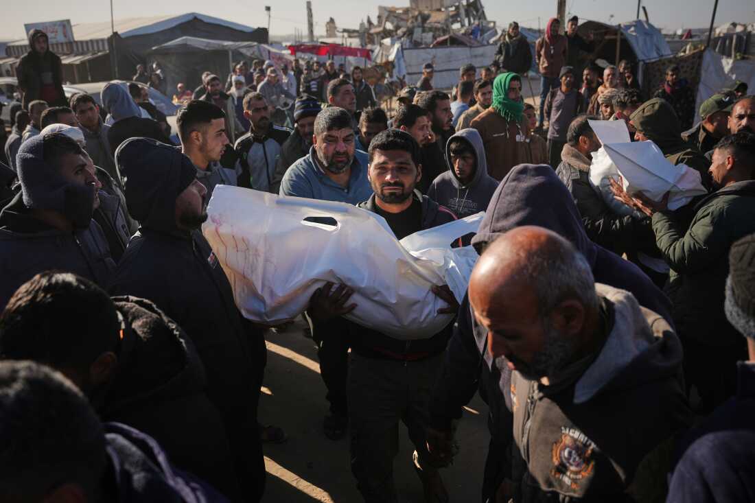 A Palestinian man carries the body of Sham Abu Hadaiyd, who was killed in an Israeli strike on a tent in Khan Younis, Gaza Strip, Saturday, Jan. 31, 2026.