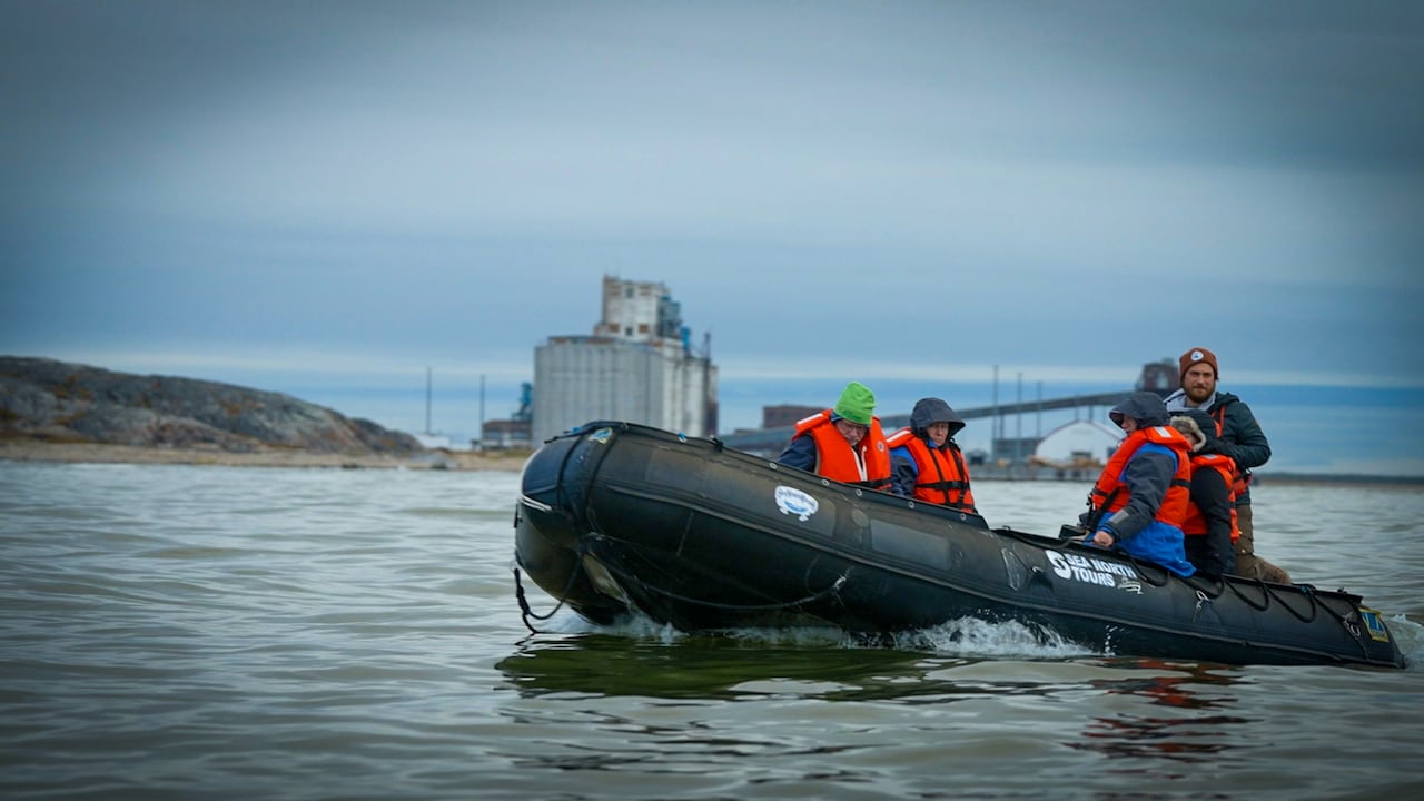 A group of people are in a boat in a lake.
