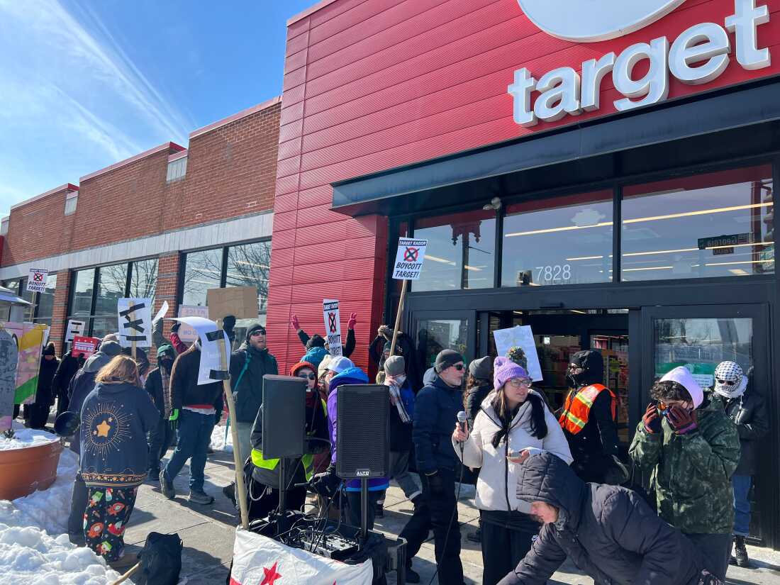 Small group of anti-ICE protesters hold picket signs in front of Target store in Washington, D.C.