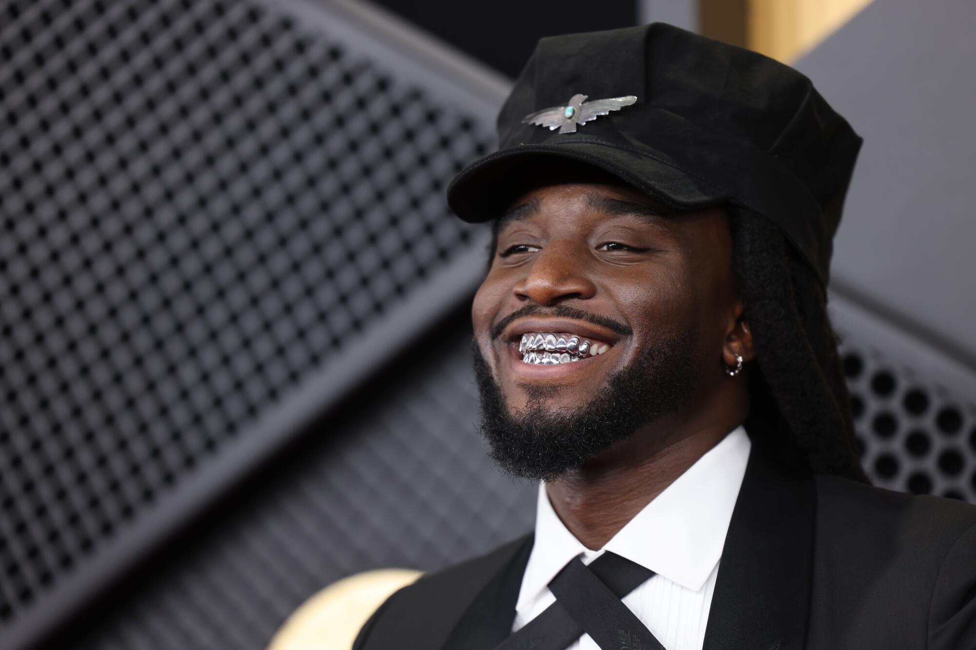 Shaboozey smiles at the Grammys red carpet