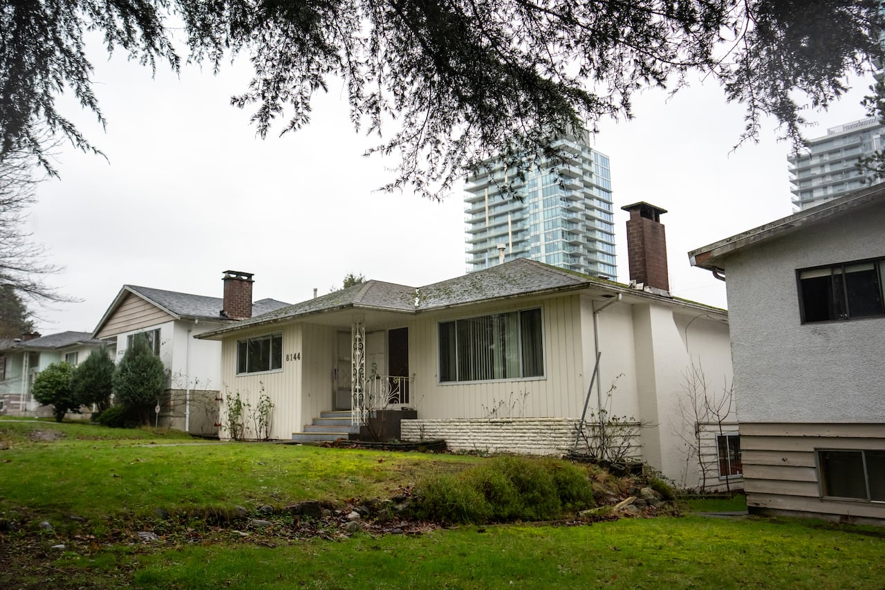An older house is pictured in front of newer condos