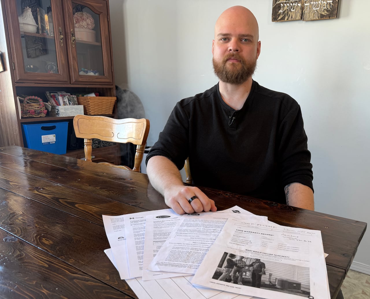 A man sits at a table with documents laid out. 
