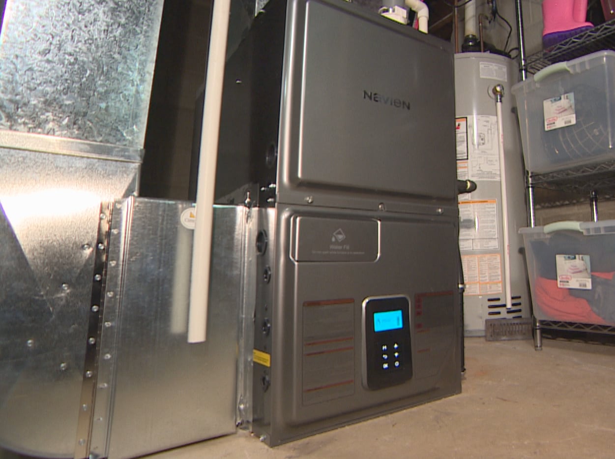 A home furnace in a basement with nearby storage shelves.