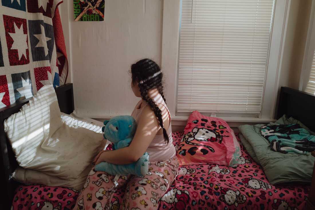 J.J.'s daughter holds a stuffed animal in her room in Minneapolis. A few weeks ago, she recorded on her phone federal agents detaining her older brother.